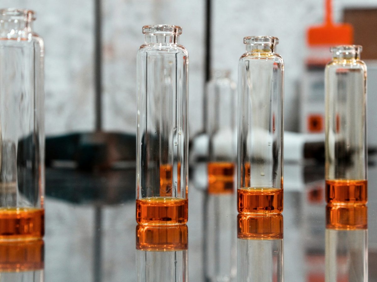 Bernsteinfarbene Autosampler-Vials auf einer reflektierenden Laborbank